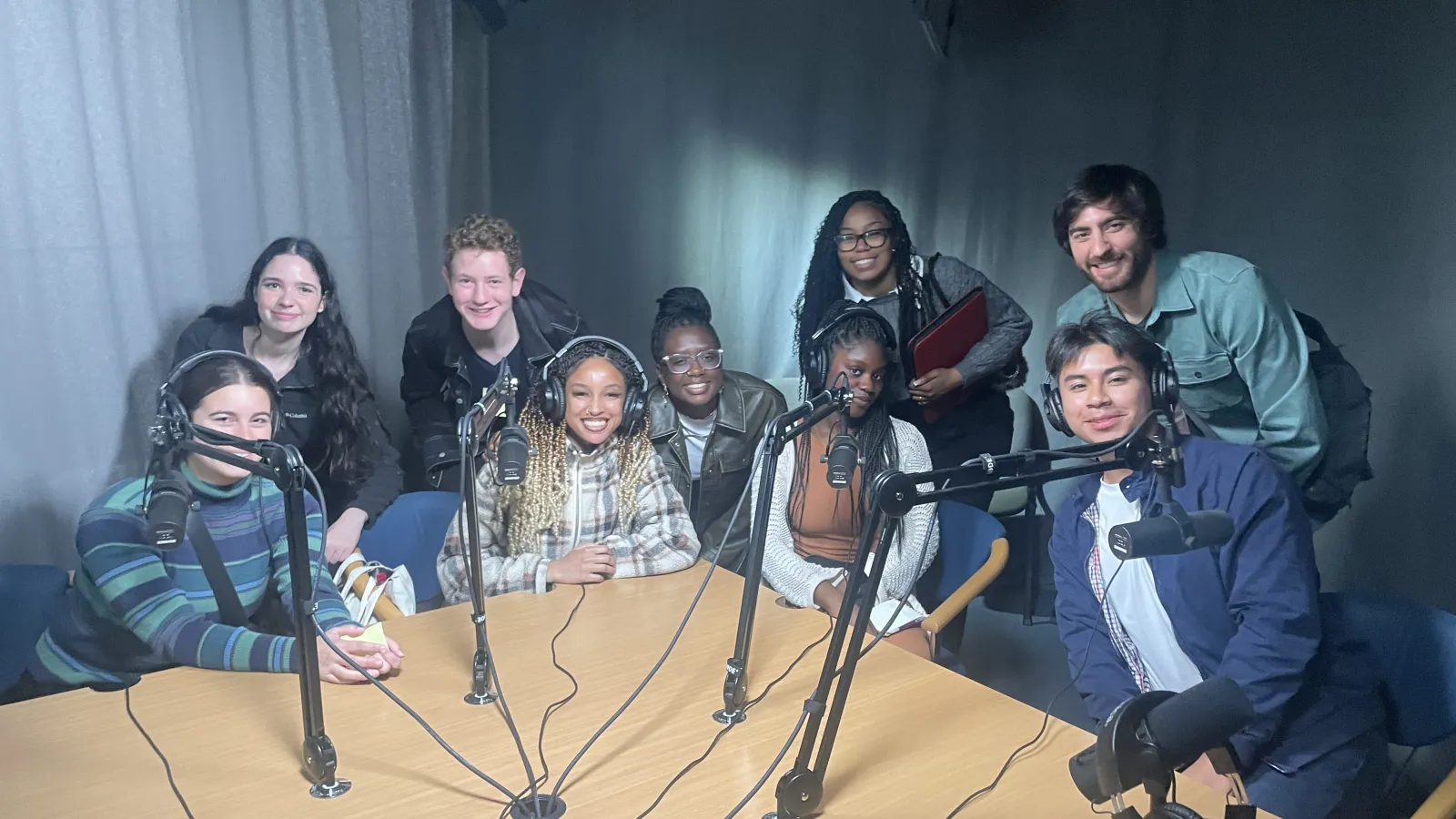 a group of students sitting around table at podcast session