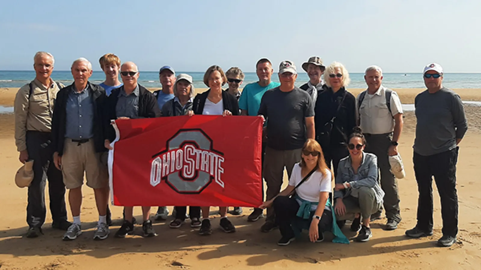 Tour participants gather for a group photo on Omaha Beach.