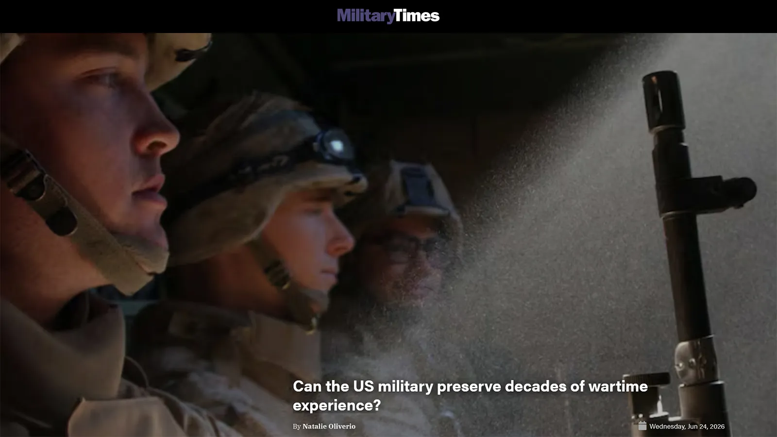 Armed and armored U.S. troops sitting shadowed in a military vehicle with a sun ray shining in