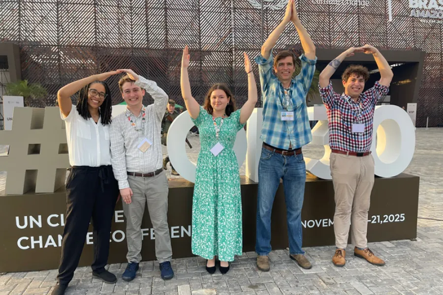 Profs. Eaglin and Elmore in O-H-I-O stance with students in front of COP30 sign