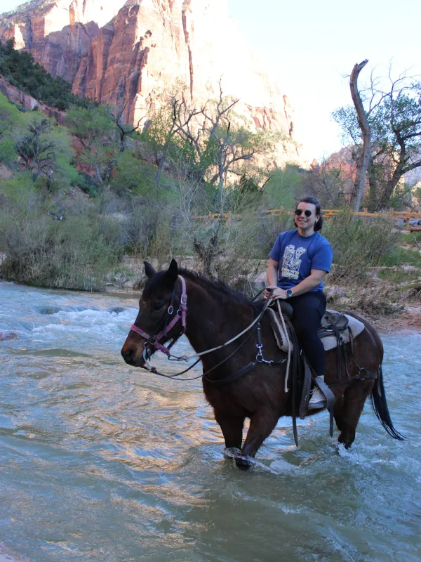 Emma Todd on a horse walking through a river