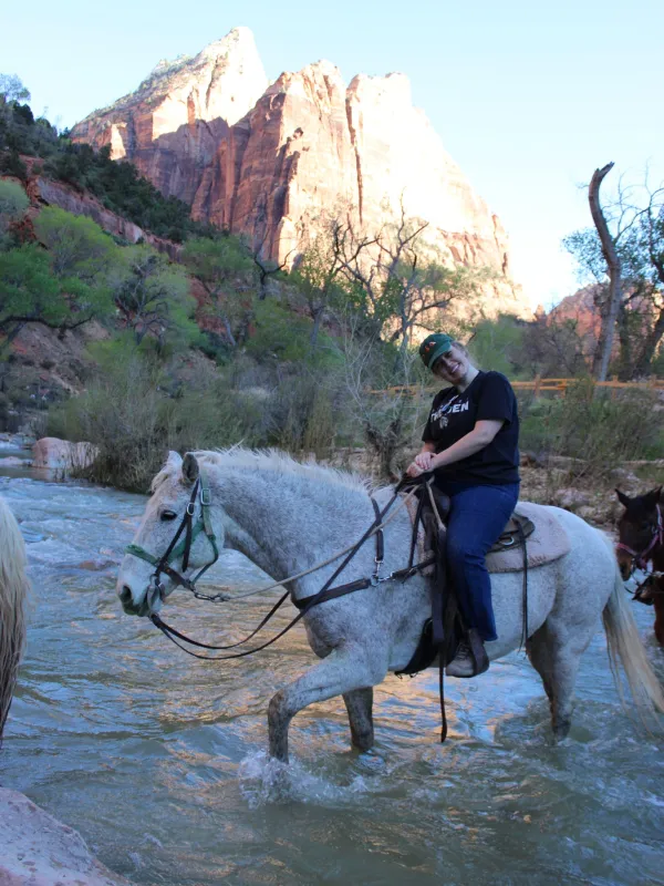 Tara Godwin on a horse walking through a river