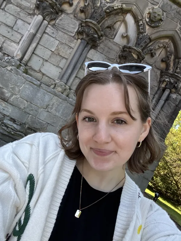 Woman standing in front of medieval abbey ruins