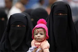 two women in black attire holding a baby
